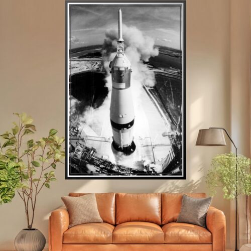 High-angle black and white photographic poster of a space rocket launching from a pad with smoke and flame.