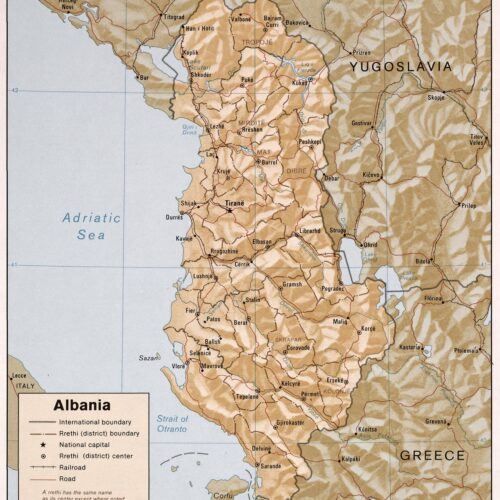 Vintage cartographic map of Albania showing regional boundaries, cities, and surrounding seas in warm ochre and cream tones with precise line work.