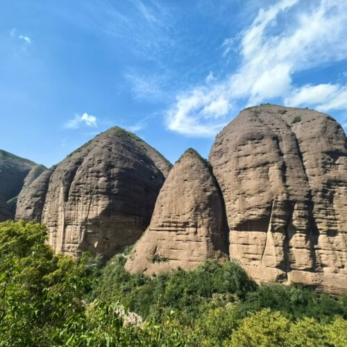 Photographic print of Shuiliandong Scenic Area featuring massive sandstone rock formations against blue sky with green vegetation below.