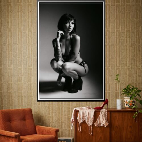 Black and white intimate portrait of a sensual tattooed woman in contemplative pose with dramatic lighting and high contrast monochrome photography.