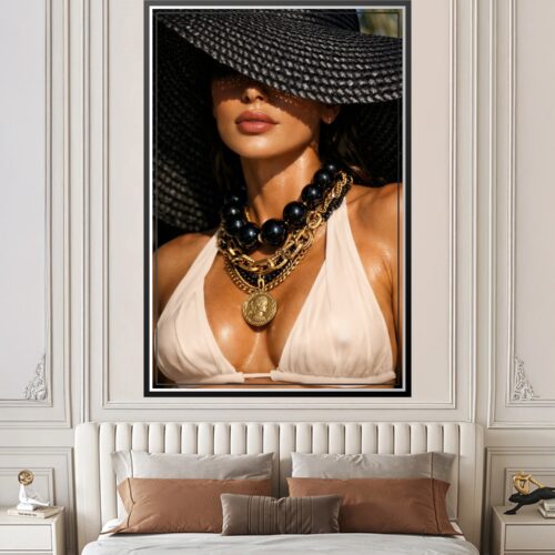 Sultry photographic fashion portrait of a woman wearing a wide black hat, white halter top, and maximalist gold chain necklaces with black pearl details against dramatic lighting.