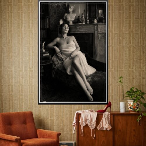 Vintage noir portrait of a contemplative woman in draped fabric, seated in an ornate interior with classical busts and period furnishings, monochromatic photography.