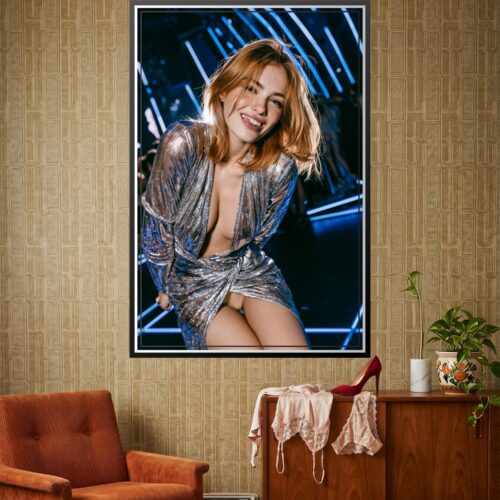 Photographic portrait of a woman with windswept auburn hair and freckles, wearing a shimmering silver wrap dress against a blue neon backdrop with radiating light rays.